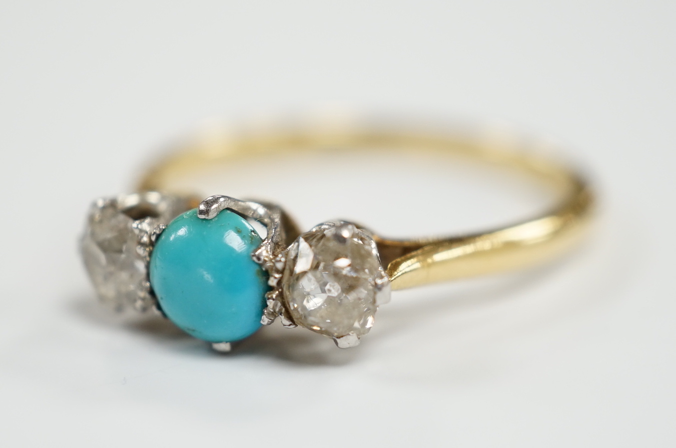 An 18ct, single stone turquoise and two stone diamond set ring, size O, gross weight 2.9 grams.